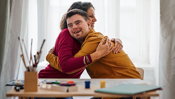 Volunteer hugging young man