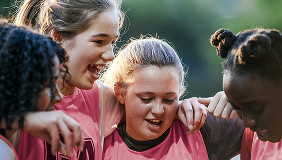 Young girls playing netball to improve their mental health