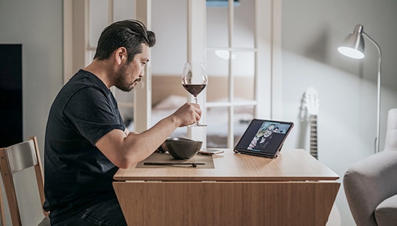 man at a desk with a glass of wine