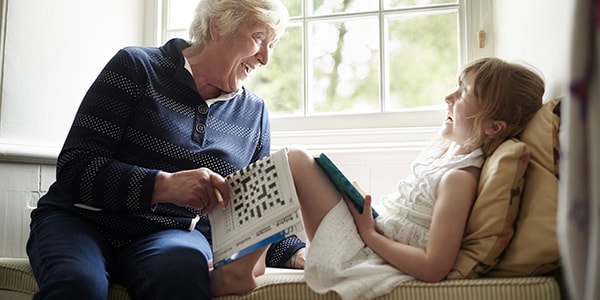 An elderly woman and child a crossword together