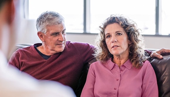 Couple sitting on the lounge talking to a marriage counsellor