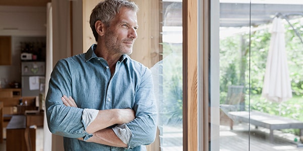 Man with vasectomy looking out of window