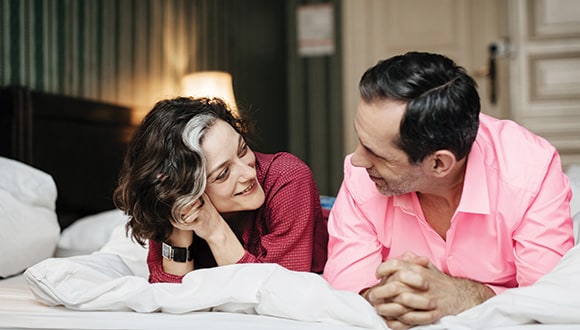 Couple talking on bed discussing loss of libido during menopause